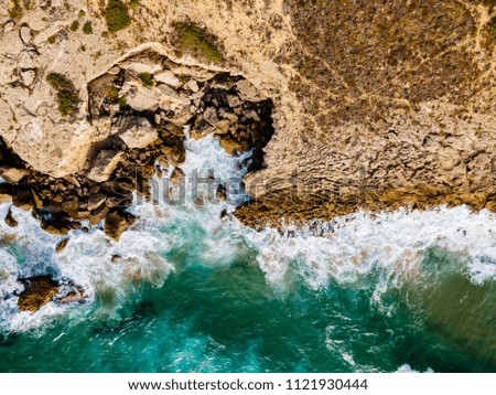 Aerial Drone View Of Dramatic Ocean Waves Crushing On Rocky Landscape