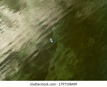 Aerial Drone View. Fishing Boat On The Water. Algae Bloom In The Water, Clouds Are Reflected.