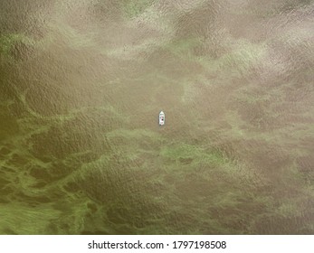 Aerial Drone View. Fishing Boat On The Water. Algae Bloom In The Water, Clouds Are Reflected.