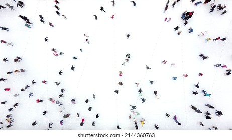 Aerial Drone View Flight Over Many People In Colorful Clothes Skating On An Open-air Ice Rink In Winter. Ice Skating Top View. City Park Ice Rink. Winter Outdoor Activities. Skating Sport Background