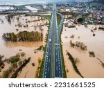 Aerial drone view of flooded fields. Floodwaters near highway. Aftermath of devastating river flood in autumn. Catastrophic floods. Overflowing river, view from above.	
