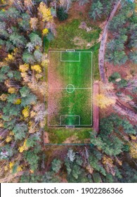 Aerial Drone View Of Football Soccer Pitch Field, Green Grass Fall Autumn Vibrant Pitch Playground With Fallen Multicolored Leaves In The Forest, Hidden In The Woods