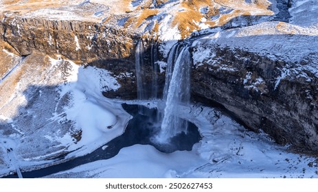 Aerial drone view of frozen Seljalandsfoss waterfall with snow in Iceland - Powered by Shutterstock