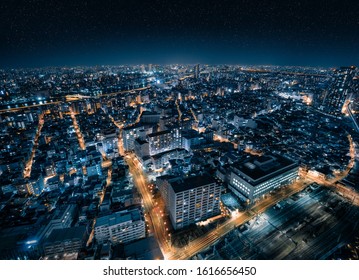 Aerial Drone View Of Futuristic City Skyline With Starry Night Sky In Tokyo, Japan