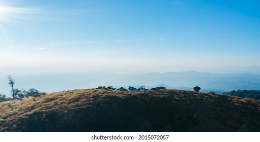 Aerial drone view of group of cars parking on the top of hill and traveller enjoy with 360 degree view of meadow landscape and beautiful mountain.