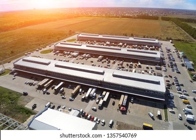 Aerial Drone View Of Group Of Large Modern Industrial Warehouse Or Factory Buildings In Suburban City Area.Logistic Transportation Cargo Terminal