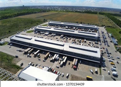 Aerial drone view of group of large modern industrial warehouse or factory buildings in suburban city area.Logistic transportation cargo terminal