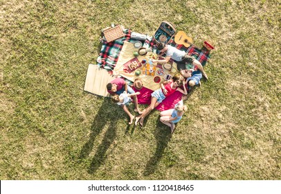 Aerial Drone View Of Happy Families Having Fun With Kids At Picnic Barbecue Party - Multiracial Happiness And Love Concept With Mixed Race People Playing With Children At Park - Warm Bright Filter