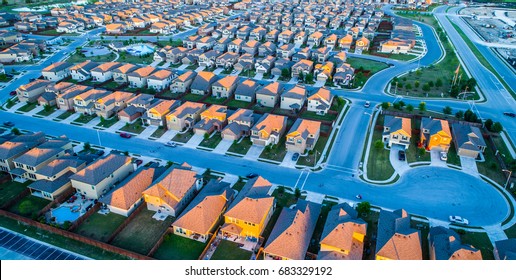 Aerial Drone View High Above Rows And Square Cookie Cutter Houses In North Austin Texas Near Round Rock , A Growing Suburb Of ATX , With Cup De Sac And Sunset Colors On Rooftop Of Suburbia