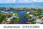 Aerial Drone View of Homes Featuring Docks on Blue Bay Waters Surrounded by Mangroves in Bonita Springs, Florida and the Gulf of Mexico in the Background with a Clear Sky