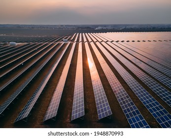 Aerial drone view of large solar panels at a solar farm at bright spring sunset. Solar cell power plants, colorful HDR photo - Shutterstock ID 1948870993