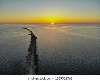 Aerial drone view of a long breakwater and sunset - Powered by Shutterstock