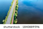 Aerial drone view of motorway road and cycling path on polder dam, cars traffic from above, North Holland, Netherlands
