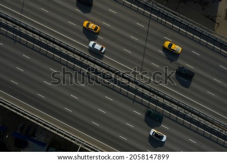 Aerial drone view on highway bridge with different automobies. Road with four lanes traffic flow in both directions. Many cars, trucks on the road. Urban transportation system