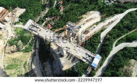 Aerial drone view on highway bridge road under construction. Construction of the viaduct on the modern new road.