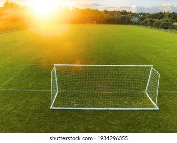 Aerial Drone View On A Small Soccer Pitch. Football Training Ground From Above View. Sunset Time. Sun Flare. Empty Green Grass Field