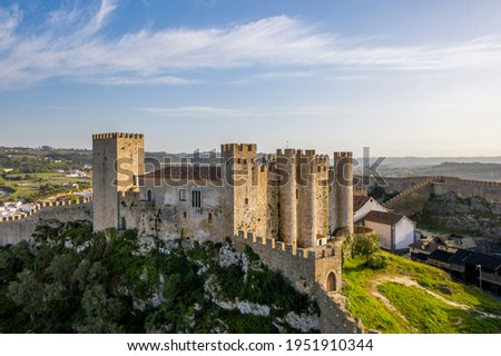 Aerial drone view over Obidos medieval Castle, in Obidos Village, Portugal. Sunset golden hour.