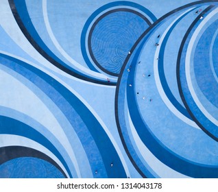 Aerial Drone View Of People Walking Over A Creative Abstract Circular Swirl Designed Patterned Floor