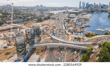 Aerial drone view of Rozelle Interchange showing major construction works and the large chimney towers with Anzac Bridge and Sydney City in the background in March 2023  