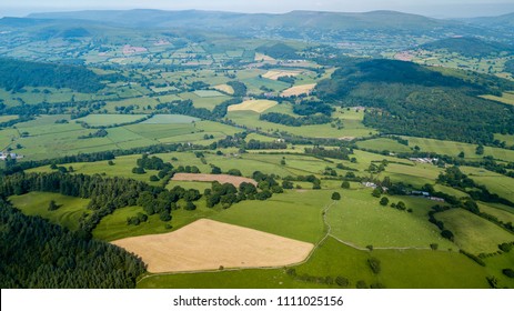 Aerial drone view of rural Wales showing farmed fields and green rolling hills - Powered by Shutterstock