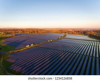 Aerial Drone View Of Solar Panels At A Solar Energy Generation Farm At Sunset In South Wales, UK