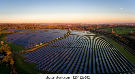 Aerial Drone View Of Solar Panels At A Solar Energy Generation Farm At Sunset In South Wales, UK