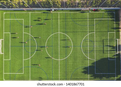 Aerial Drone View From The Sport Center During The Training Of The Football Team. Players Are Playing A Soccer Match, Aerial Shot With A Drone From A Altitude At Summer Day.