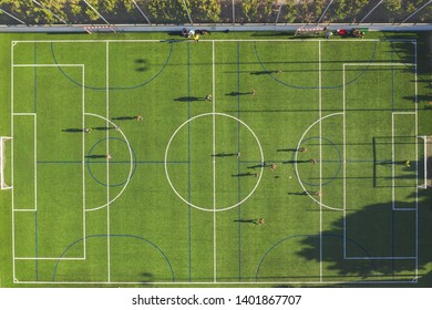 Aerial Drone View From The Sport Center During The Training Of The Football Team. Players Are Playing A Soccer Match, Aerial Shot With A Drone From A Altitude At Summer Day.