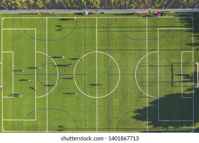 Aerial Drone View From The Sport Center During The Training Of The Football Team. Players Are Playing A Soccer Match, Aerial Shot With A Drone From A Altitude At Summer Day.