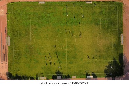 Aerial Drone View From The Sport Center During The Training Of The Football Team. Players Are Playing A Soccer Match, Aerial Shot With A Drone From A Altitude At Summer Day.