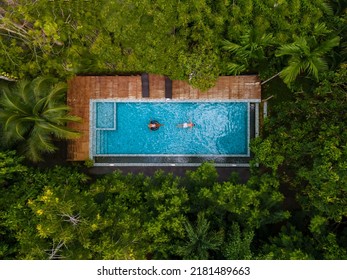 aerial drone view of swimming pool in the jungle of Krabi Thailand, aerial view with a drone above swimming pool in the jungle of Thailand. couple men and woman in pool from above