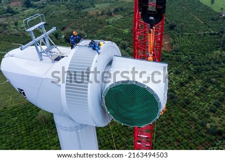 Aerial drone view of wind turbine engine under construction to create alternative power. Green energy concept to reduce global warming climate change and pollution.