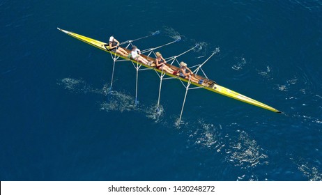 Aerial Drone View Of Yellow Sport Canoe Operated By Women's Rowing Team On Deep Blue Sea