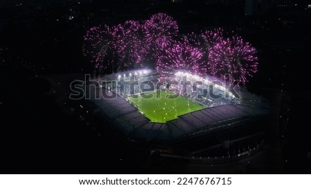 Aerial Establishing Shot of a Whole Stadium with Soccer Final Match Starting. Teams Play, Crowd of Fans Cheer, Fireworks Launched From Top of The Arena. Football Tournament, Cup TV Broadcast.