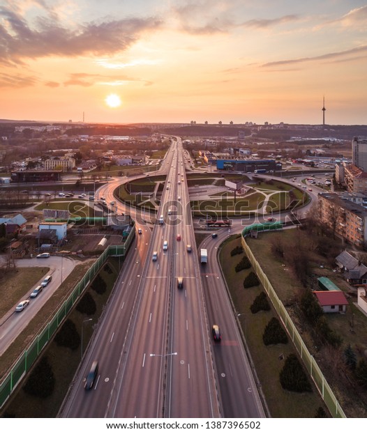 Aerial evening view of three\
level highway intersection with transport in motion in Vilnius,\
Lithuania