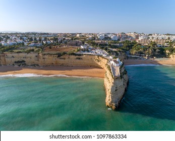 Aerial famous rocky seascape cape and Senhora da Rocha church on top of the cliff, in Algarve south coast, Portugal.
