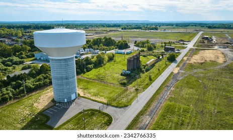 Aerial farmland farm fields, white water tower, abandoned buildings silos, destroyed train tracks - Powered by Shutterstock