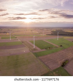 Aerial: FIelds and windmills in sunset light. Drone view