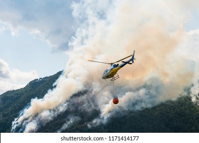 Aerial Firefighting With Helicopter On A Big Wildfire In A Pine Forest