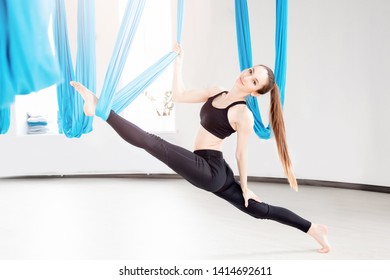 Aerial fly yoga young beautiful women gymnast in blue hammock. - Powered by Shutterstock