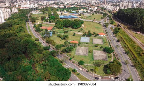 Aerial Footage of "Sedes", Taubaté Park, showing the park and cityscape on a sunny day - Shutterstock ID 1983897884