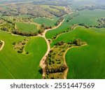 Aerial footage of the stunning Badlands of Ruhama, featuring rolling hills, unique erosion patterns, and lush greenery. The video captures the natural beauty and geological features of this iconic lan