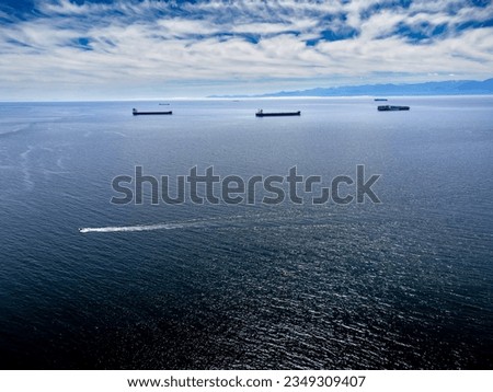 Aerial freighters anchored off Vancouver Island overlooking the Olympic Peninsula in Washington State in Victoria British Columbia Canada.