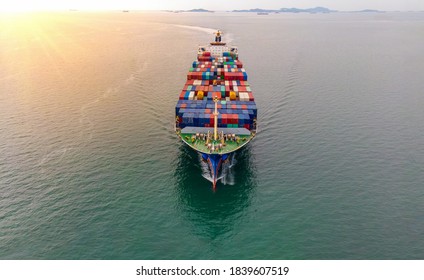 Aerial In Front Of Cargo Ship Carrying Container And Running With Crew That Working Rope Stand By For Tug Boat.