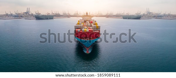 Aerial in front of cargo ship carrying
container and running 
near international custom depot sea port
concept smart logistic service.  forwarder
mast