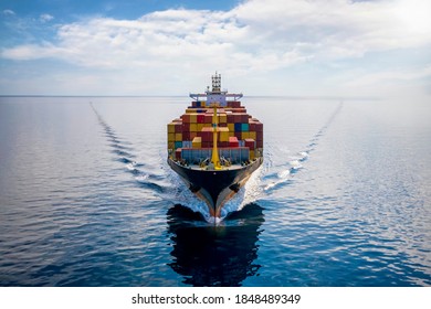 Aerial front view loaded container cargo vessel traveling over calm ocean