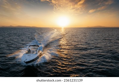 Aerial front view of a speedboat cruising over the sea during sunset time with copy space - Powered by Shutterstock