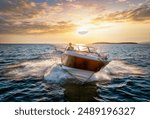 Aerial front view of a sports motor boat cruising with high speed over the blue sea during summer sunset time