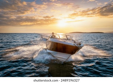 Aerial front view of a sports motor boat cruising with high speed over the blue sea during summer sunset time