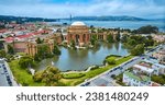 Aerial full view Palace of Fine Arts lagoon and colonnade pillars with Golden Gate Bridge